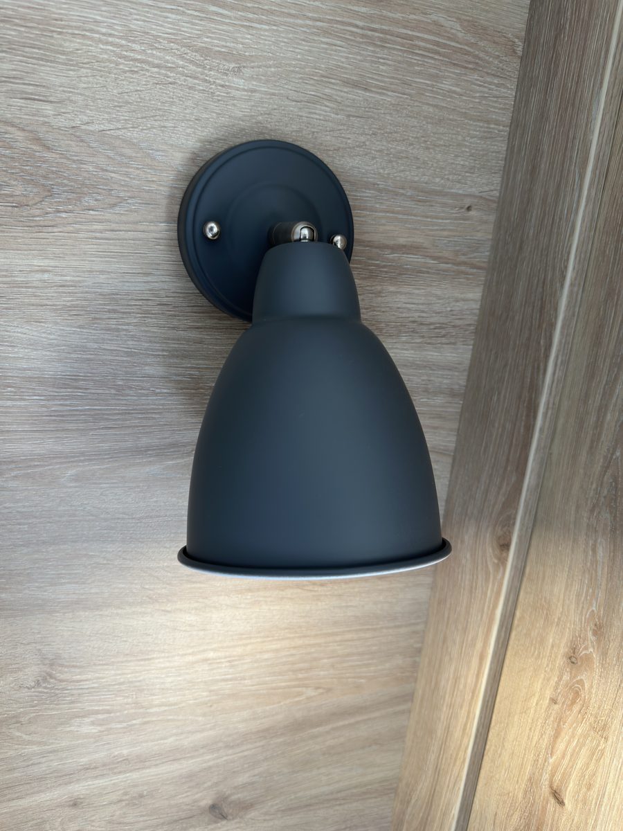 The Langdale, a black wall light against oak