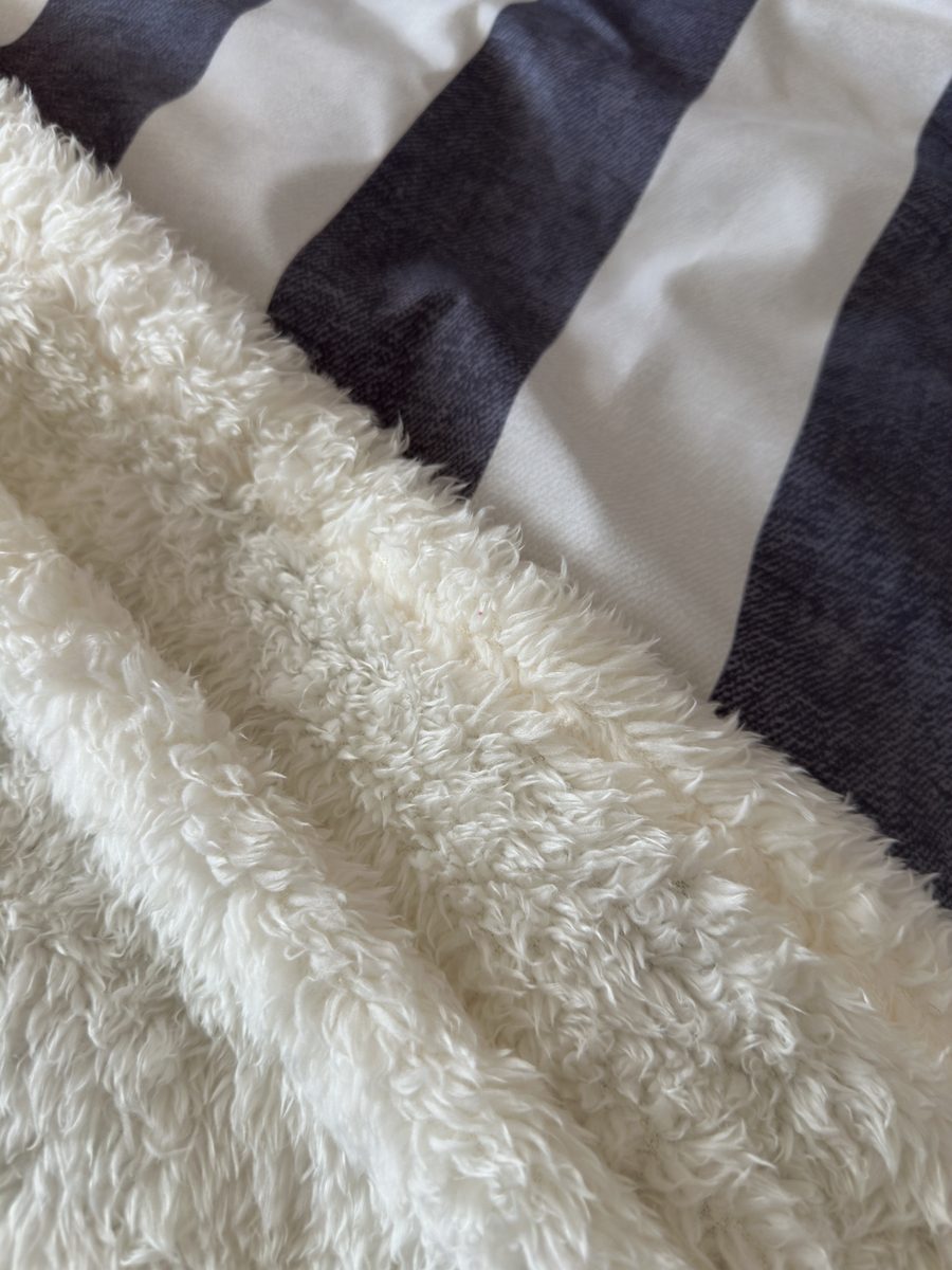 The Edmonton, a soft throw against a navy striped cushion