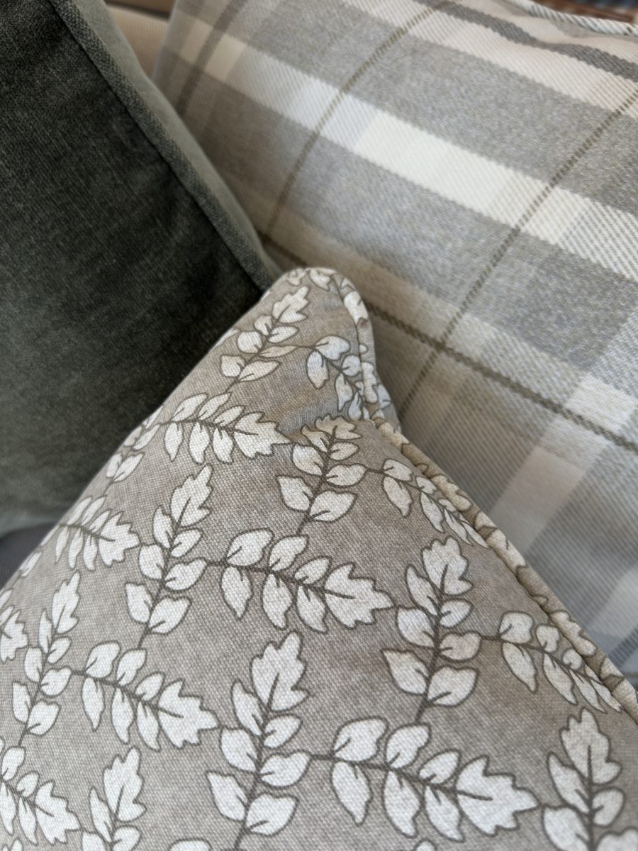 The Vendee, a leaf print cushion against check