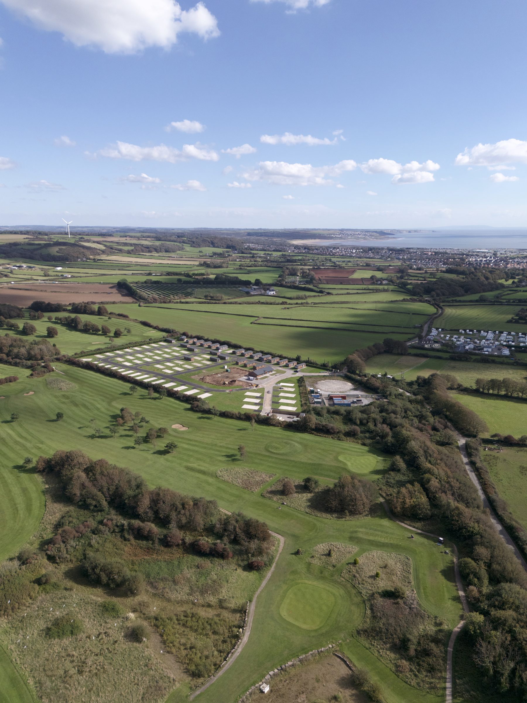 Nottage Park Lodges from the air, ringed by golf courses, with Porthcawl and the coast beyond