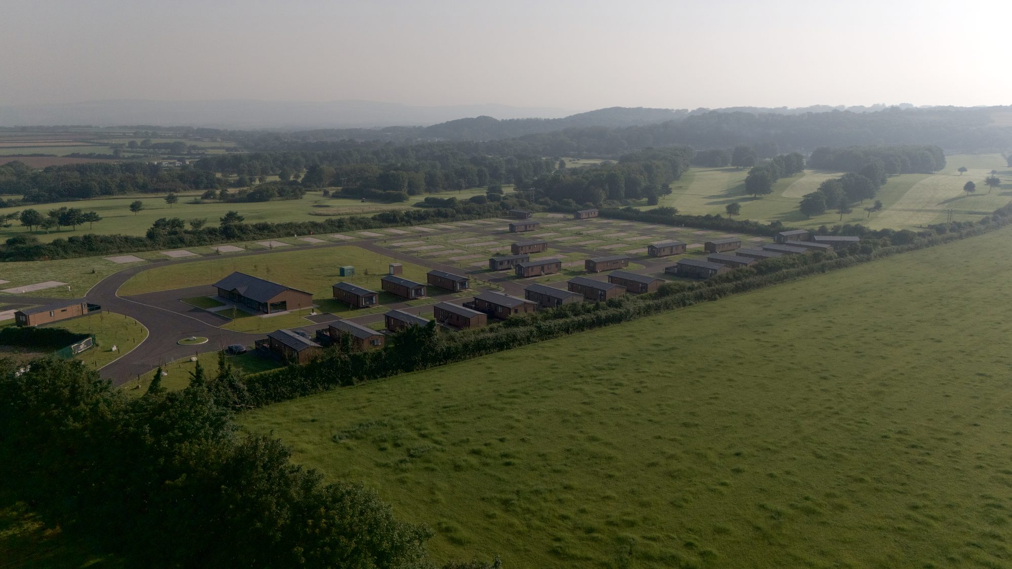 The boundary hedge at Nottage Park Lodges, with the golf beyond