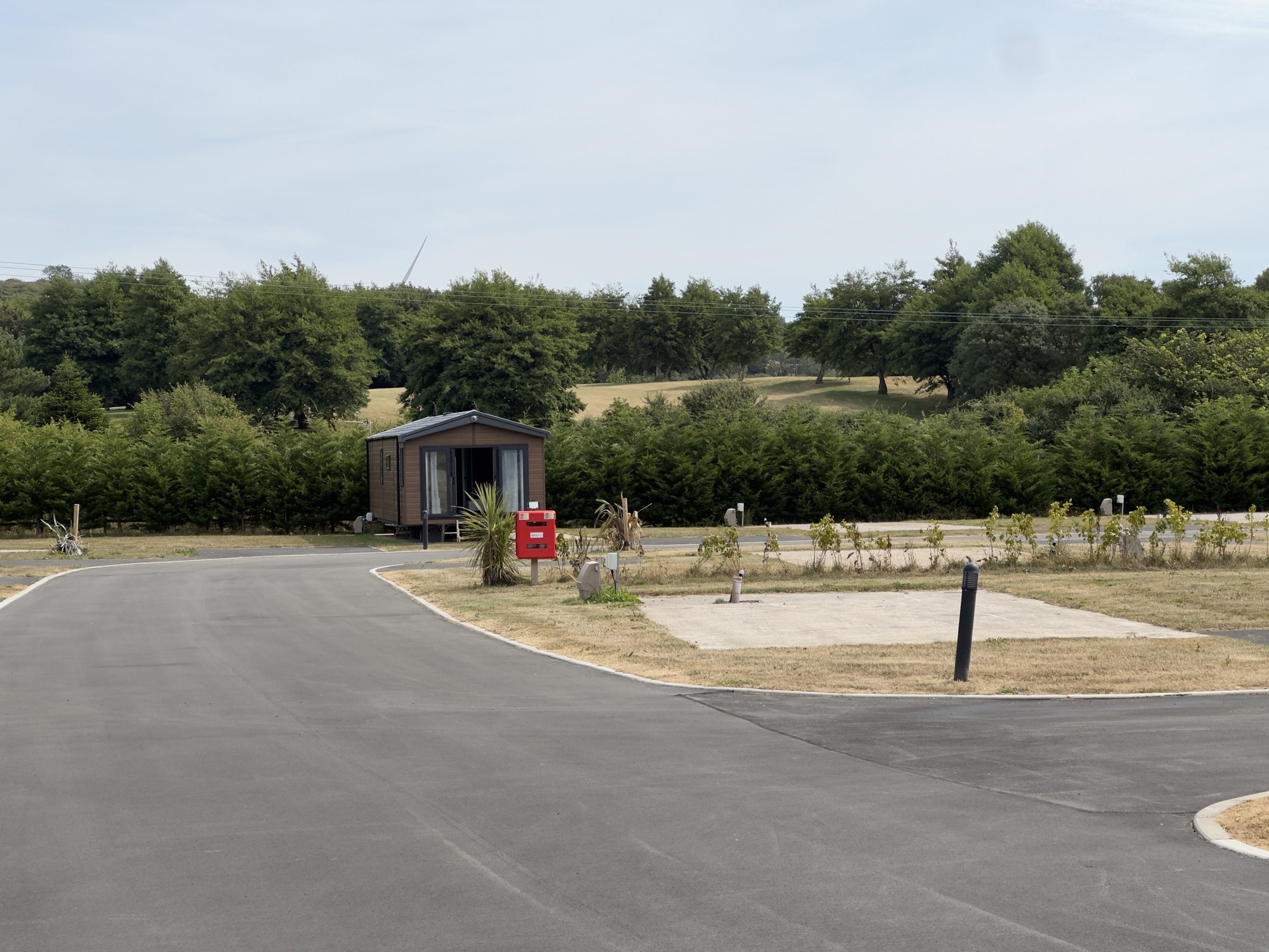 An open pitch at Nottage Park Lodges, with the boundary planting and the golf course beyond