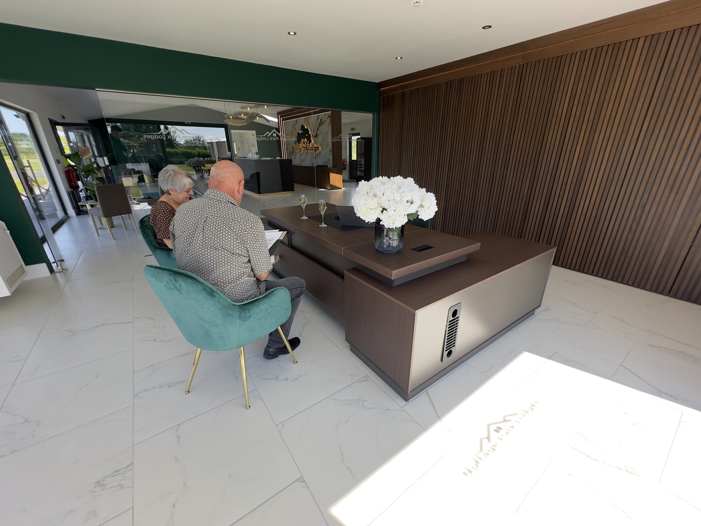A couple going through the paperwork at the reception desk at Nottage Park Lodges
